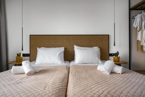 a large bed with two pillows on top of it at Hotel Papillon in Argasi
