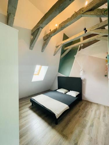 - une chambre avec un lit dans un dortoir doté de parquet dans l'établissement Maison Les Écuries-Piscine-Castelnaud, à Castelnaud-la-Chapelle