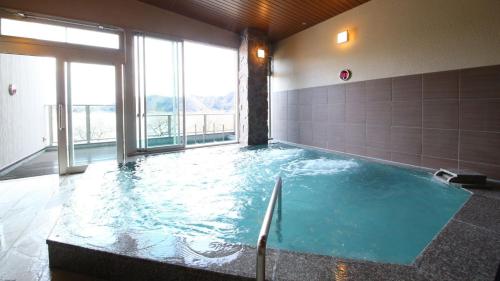 a large pool of water in a room with windows at Ashiwada Hotel in Fujikawaguchiko