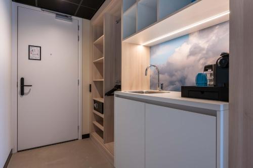 a kitchen with a sink and a wall with a window at Hotel Waterstate in Goes