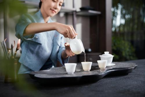 a woman pouring coffee into cups on a table at HUALUXE Yangjiang City Center in Yangjiang