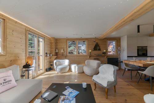 a living room with white chairs and a table at Homency - Chalet La Pavicha in L'Alpe-d'Huez