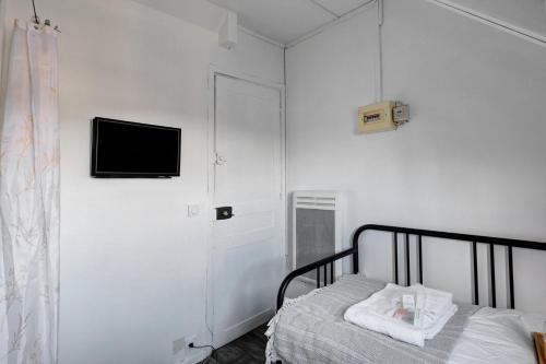 une chambre avec un lit et une télévision sur un mur dans l'établissement 593 Suite Aurélie - Superbe Appartement à Paris, à Paris
