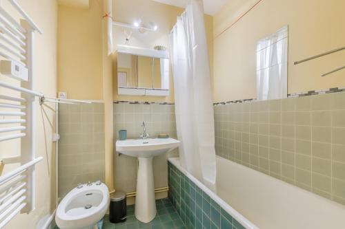 une salle de bain avec un lavabo et des toilettes dans l'établissement L’Évasion Atlantique - Appt à 5 min de la plage, à Saint-Jean-de-Monts
