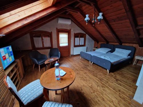 a living room with a bed and a table at Morvai Panzió in Mogyoród