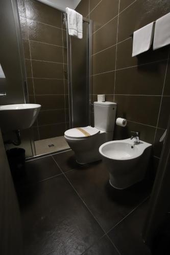 a bathroom with a toilet and a sink at Tiby Hotel in Modena