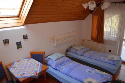 sypialnia z 2 łóżkami, stołem i oknem w obiekcie Orchidea Apartman w Hévízie