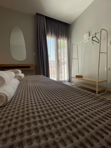 a bedroom with a large bed and a large window at Karamelas Vacation House in Nea Kalikratia