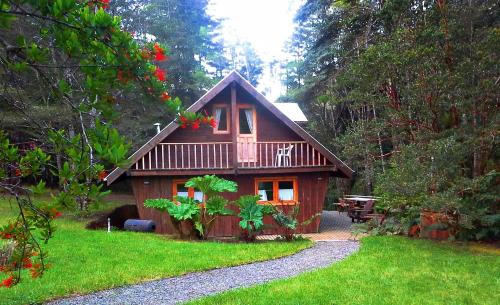 a small wooden cabin in the middle of a forest at Hotel Salto del Carileufu in Pucón