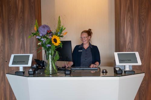 a woman sitting at a desk with a laptop at Hotel Waterstate in Goes