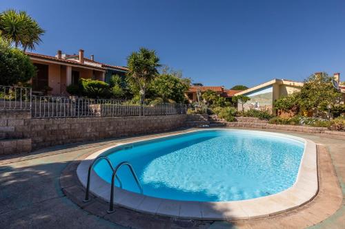 a swimming pool in a yard next to a house at Casa Shanti - 5 Minuti dalla Spiaggia con Piscina Condominiale in Santa Caterina