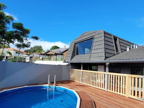 a house with a swimming pool on a deck at Luxury Bay Vacation Home 5 Ensuites & Pool in Whangaparaoa