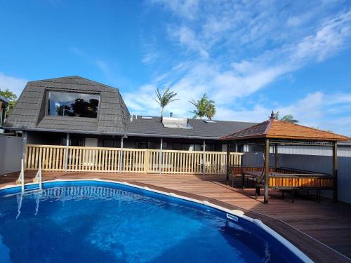 a swimming pool in front of a house at Luxury Bay Vacation Home 5 Ensuites & Pool in Whangaparaoa