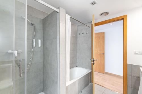 a bathroom with a shower and a bath tub at The Corner Apartments by Aspasios in Barcelona