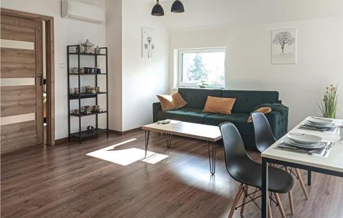 a living room with a green couch and a table at Stunning Apartment In Wilcze With Sauna in Wilcze