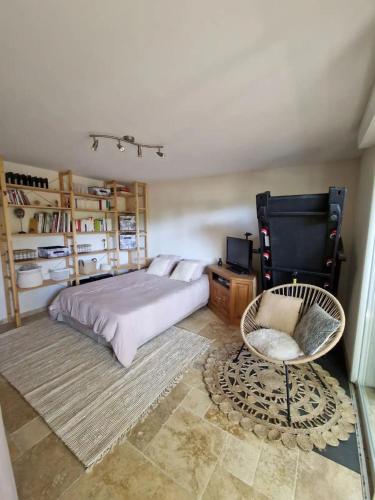 une chambre avec un lit et une chaise dans l'établissement La maison de Campagne - RENDEZ-VOUS EN PROVENCE, à Monteux