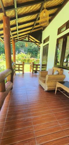 a living room with couches and a wooden floor at Sumatra Cheeky Monkeys Villa, Trekking and Tours in Bukit Lawang