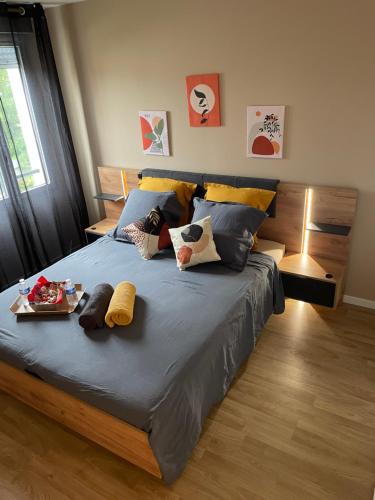 une chambre avec un lit avec des draps et des oreillers bleus dans l'établissement Paris Disneyland appartement centre-ville, parking, au coeur de l'aviron, à Vaires-sur-Marne