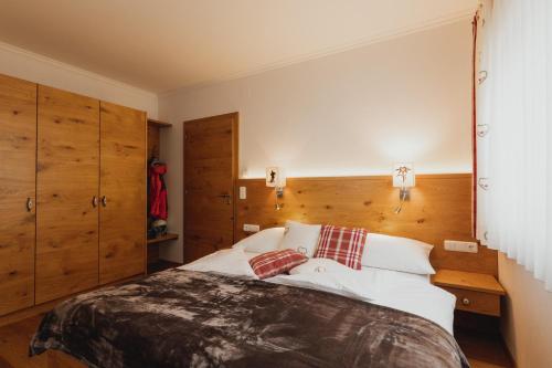 a bedroom with a large bed with wooden walls at Portis Appartements in Dienten am Hochkönig