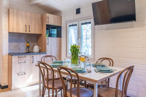 a dining room with a table and chairs at Domki - Sosnowy Las in Pobierowo