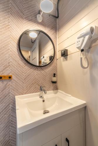 a bathroom with a sink and a mirror at Domki - Sosnowy Las in Pobierowo