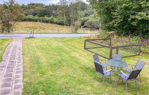 a table and chairs sitting in a yard with a field at Lovely Home In Hishult With Wifi in Drakabygget