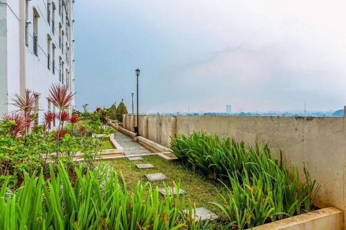 a concrete wall with plants next to a building at Good Choice and Simply Studio Apartment Margonda Residence 4 By Travelio in Depok