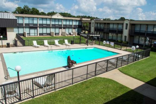 a large swimming pool in front of a building at Lamplighter Inn & Suites Pittsburg in Pittsburg