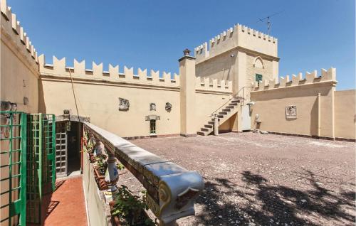 a large building with a fence and a staircase at Castello Mortellito in Spadafora