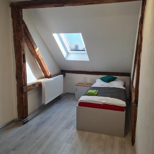 a bedroom with a bed in a attic with a window at Hauptmann5 in Waldmünchen