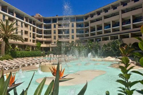 une piscine avec une fontaine en face d'un bâtiment dans l'établissement JOLI 2 PiECES AUX PIEDS DES PLAGES, à Cannes