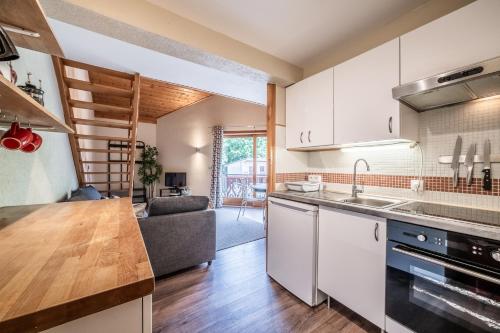 une cuisine avec un évier et une cuisinière four supérieur dans l'établissement Cypierre 10 - Duplex au centre de la station, à Morzine
