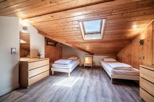 deux lits dans une chambre avec plafonds en bois dans l'établissement Cypierre 10 - Duplex au centre de la station, à Morzine