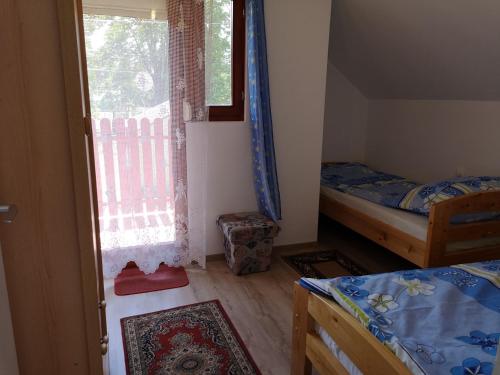 a small bedroom with two beds and a window at Petőfi 4 in Balatonmáriafürdő