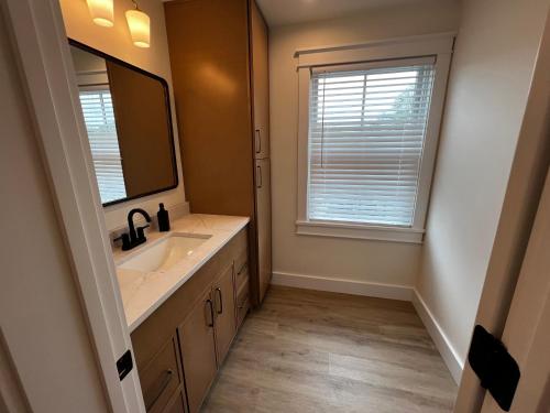 a bathroom with a sink and a mirror and a window at Montgomery Modern Luxury Stays in Montgomery