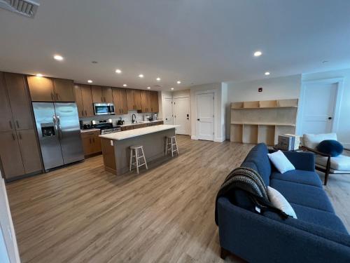 a living room with a blue couch and a kitchen at Montgomery Modern Luxury Stays in Montgomery