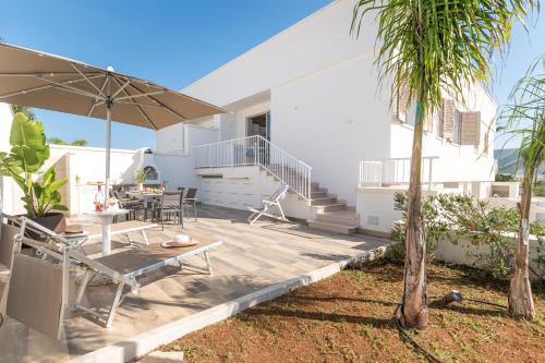 a patio with a table and an umbrella at Mare Villas Pescoluse- Design Apartment in Marina di Pescoluse
