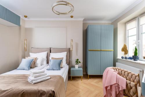 a bedroom with a bed with towels on it at Rooftop Wawel view with jacuzzi l luxury apartment in Kraków
