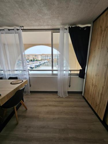 Cette chambre dispose d'une fenêtre offrant une vue sur le parking. dans l'établissement studio cabine - Sète - 6personnes - rénové - moderne - en bord de plage avec clim, à Sète