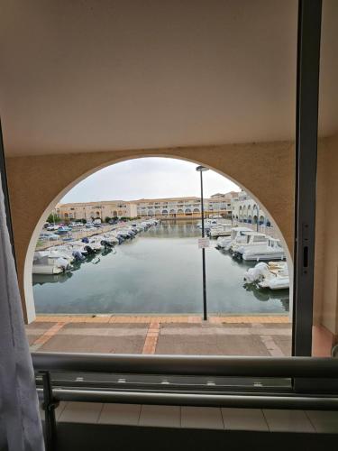 une vue d'une marina à travers une fenêtre dans l'établissement studio cabine - Sète - 6personnes - rénové - moderne - en bord de plage avec clim, à Sète