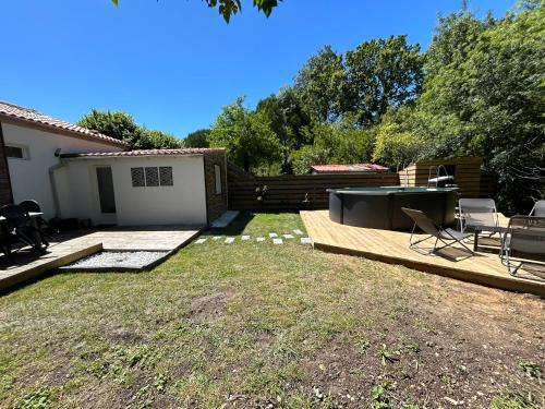 une arrière-cour avec un grill, une table et des chaises dans l'établissement Maison 8 min en voiture de Chatelaillon plage avec piscine hors sol privative, à Salles-sur-Mer