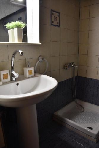 a bathroom with a sink and a bath tub at Kactro House in Samothraki