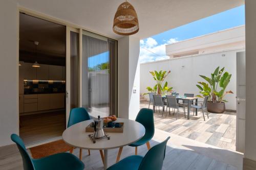 a kitchen and dining room with a table and chairs at Mare Villas Pescoluse- Design Apartment in Marina di Pescoluse