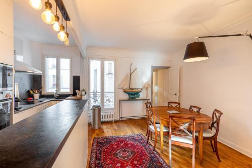 une cuisine et une salle à manger avec une table et des chaises en bois dans l'établissement GuestReady - central apartment at Les Invalides, à Paris