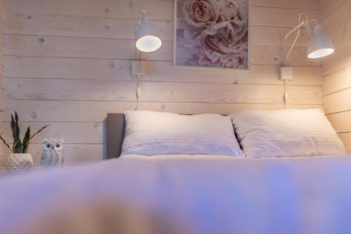 a bedroom with a bed with two white pillows at Domki - Sosnowy Las in Pobierowo