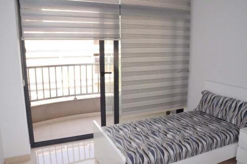 a room with a window with a couch and a balcony at Residence Prague in Al Hoceïma