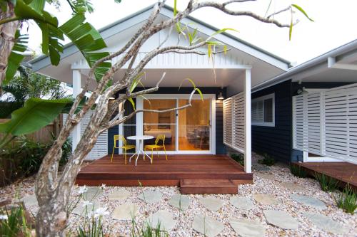 a house with a tree in front of it at The Beach Shack Byron Bay in Byron Bay