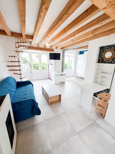 un salon avec un canapé bleu et une télévision dans l'établissement Mariella - MAISON FAMILIALE, WIFI, 500m de la plage, à Royan