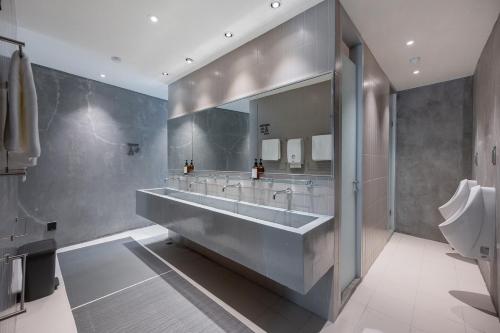 a bathroom with a large sink and a toilet at Nidhra Boutique Hotel Bangkok Sukhumvit in Bangkok