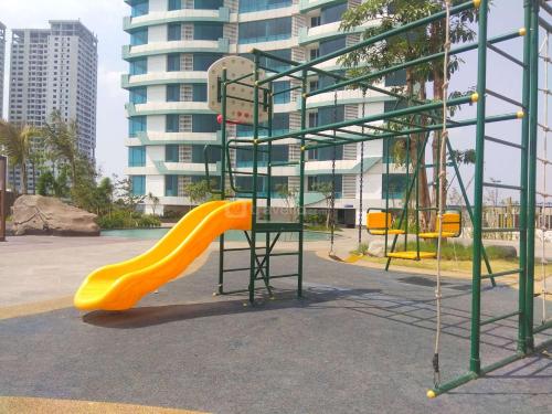 a playground with a yellow slide in a park at Good Choice and Cozy 2BR Grand Kamala Lagoon Apartment By Travelio in Bekasi